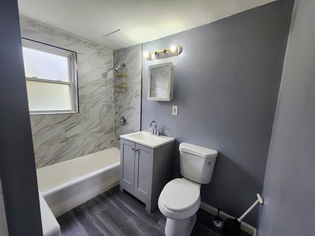 a bathroom with a granite countertop toilet a sink and bathtub