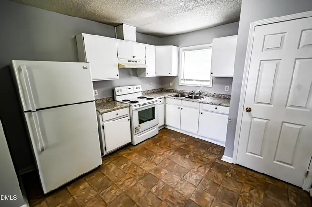 a kitchen with white cabinets and white appliances