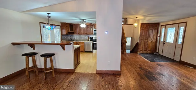 a view of a hallway with wooden floor and staircase