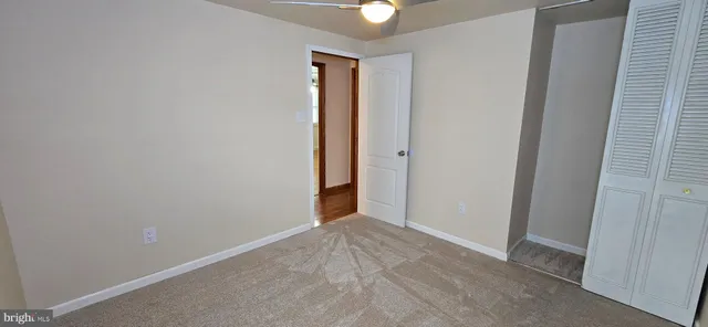 a view of a room with wooden floor and fan
