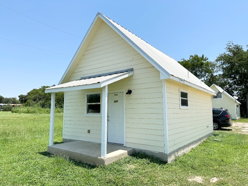a view of a small house with a yard