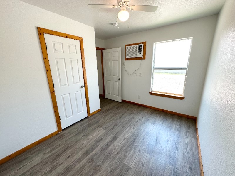 403 Free Timber Lane Stockdale, TX 78160 - Photo 4 of 9 an empty room with wooden floor and windows