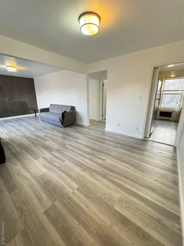 a view of a livingroom with wooden floor and window