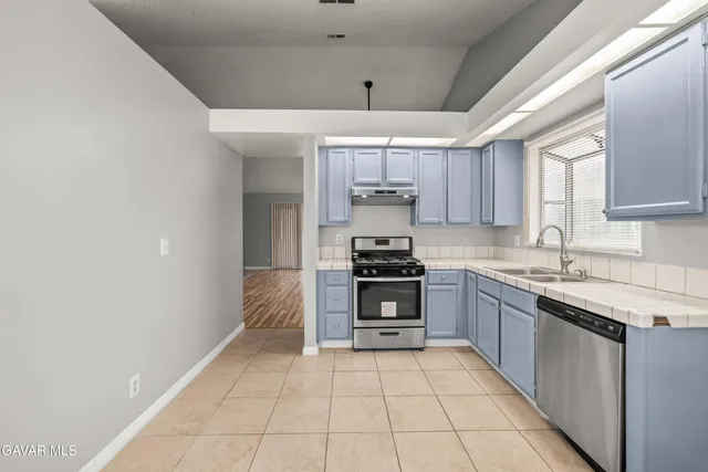 a kitchen with stainless steel appliances granite countertop a refrigerator and a stove top oven