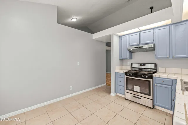 a kitchen with granite countertop white cabinets and stainless steel appliances