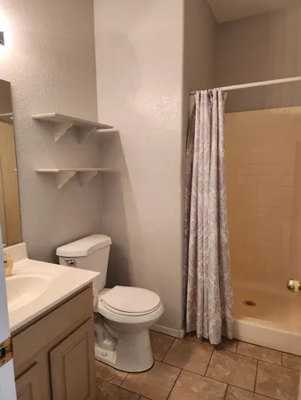 a bathroom with a toilet and a shower