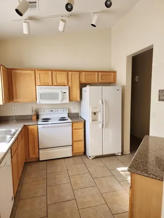 a kitchen with a refrigerator sink stove and cabinets