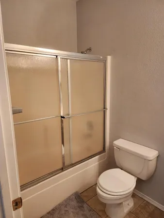 a white toilet sitting next to a shower