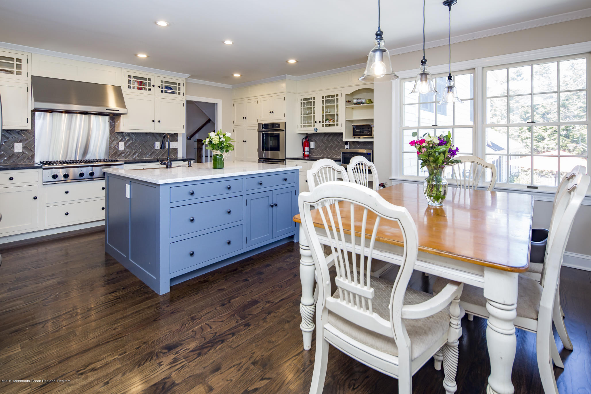 3 Evergreen Drive Rumson, NJ 07760 - Photo 7 of 37 a kitchen with stainless steel appliances kitchen island granite countertop a table chairs in it and wooden floors