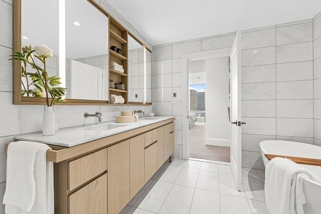 a bathroom with a granite countertop sink a toilet a mirror and shower