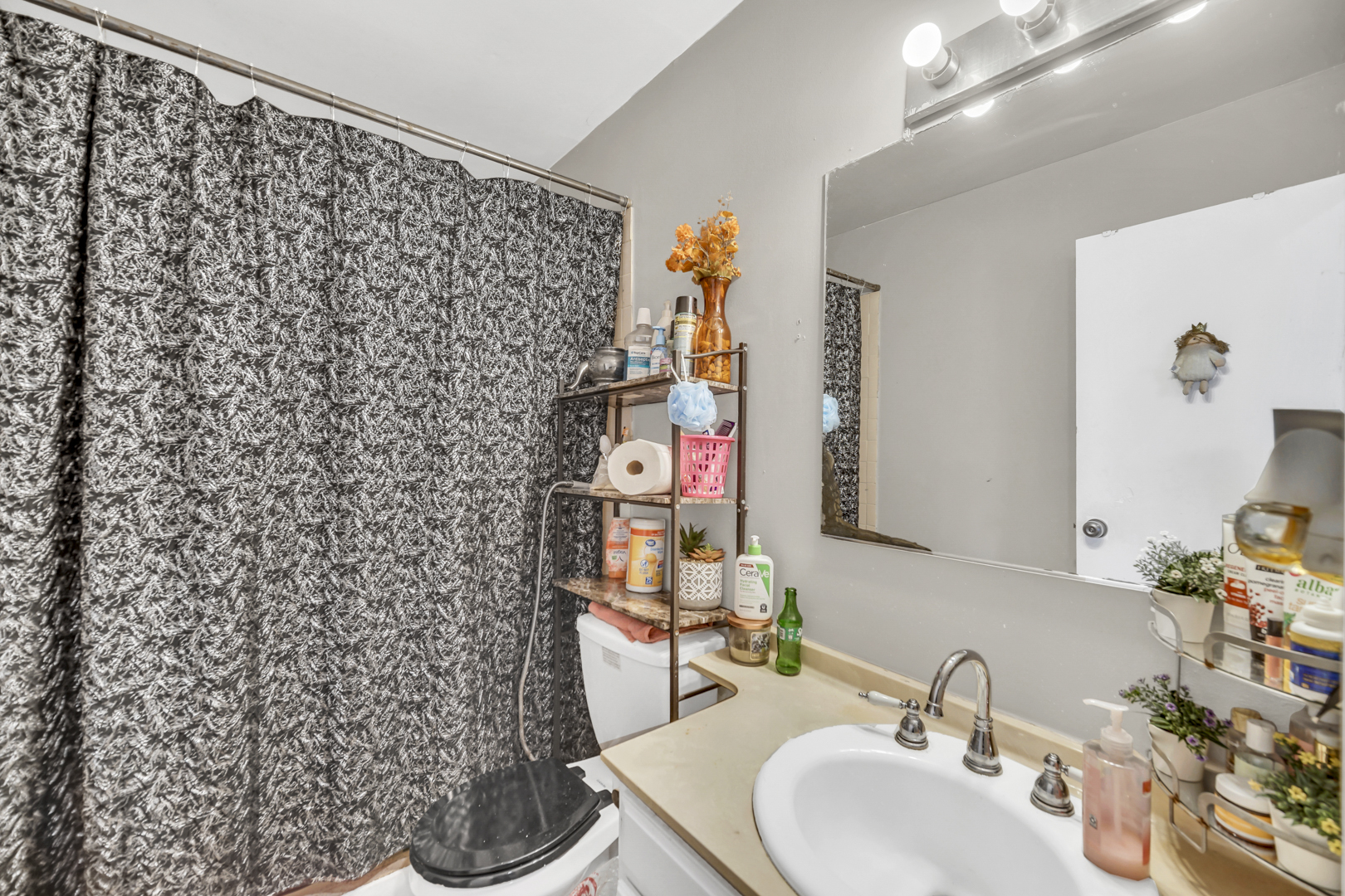 1269 Court D Hanover Park, IL 60133 - Photo 10 of 19 a bathroom with a sink a toilet and shower curtain