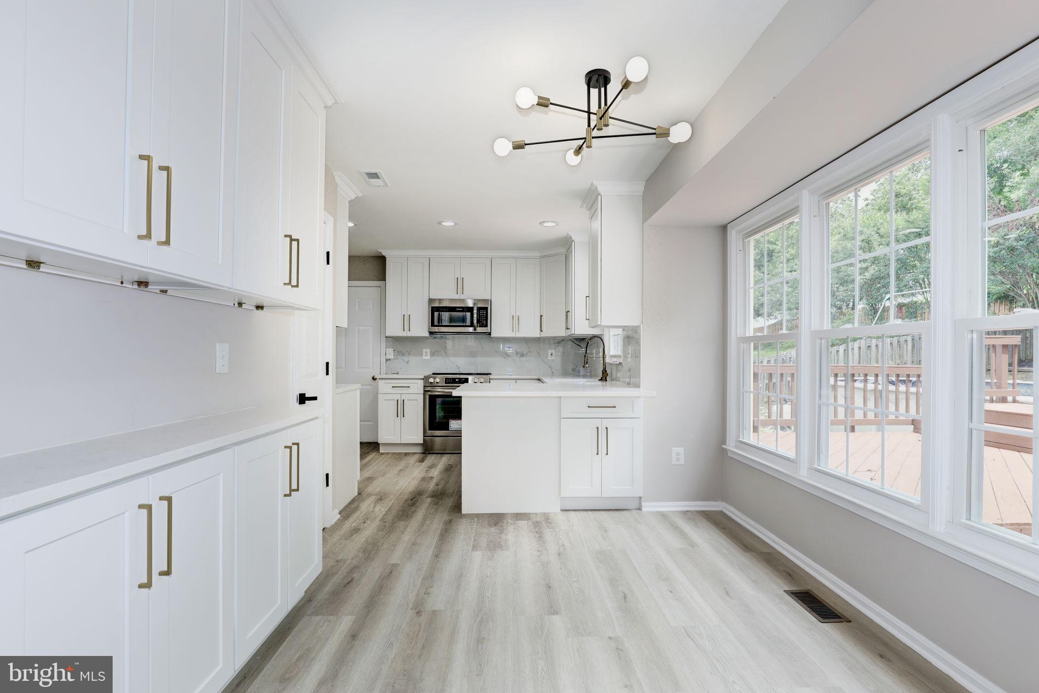 14422 Old Stage Road Bowie, MD 20720 - Photo 13 of 65 a kitchen with kitchen island white cabinets and white appliances