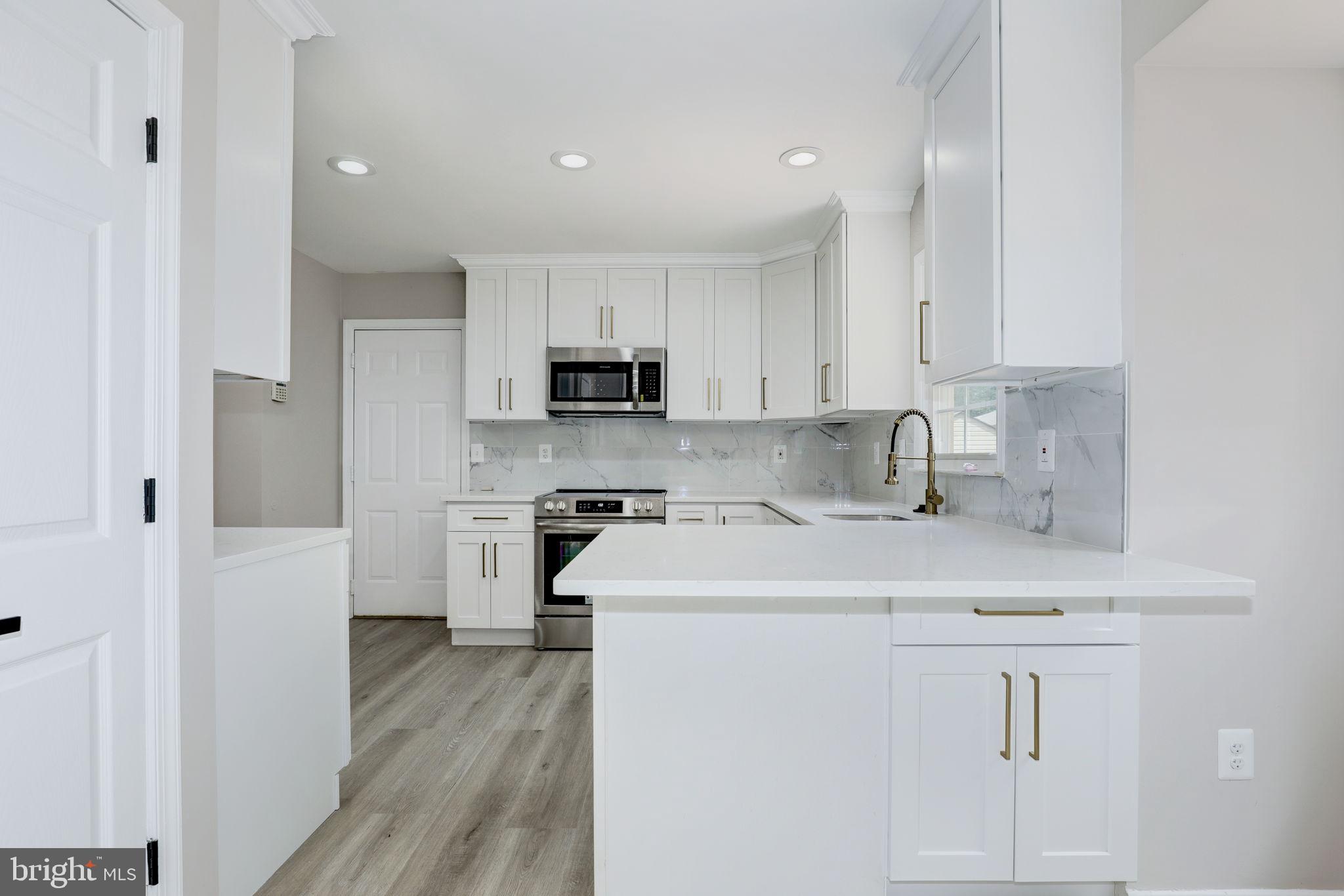 14422 Old Stage Road Bowie, MD 20720 - Photo 16 of 65 a kitchen with cabinets appliances a sink and a counter top space