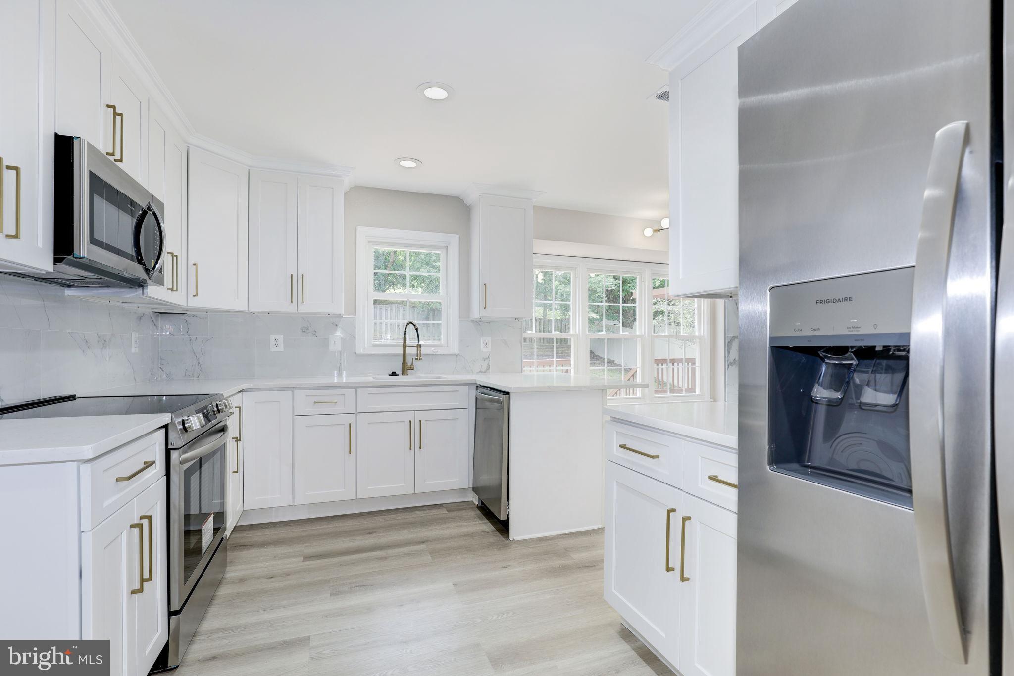 14422 Old Stage Road Bowie, MD 20720 - Photo 17 of 65 a kitchen with stainless steel appliances granite countertop a stove a sink and a refrigerator