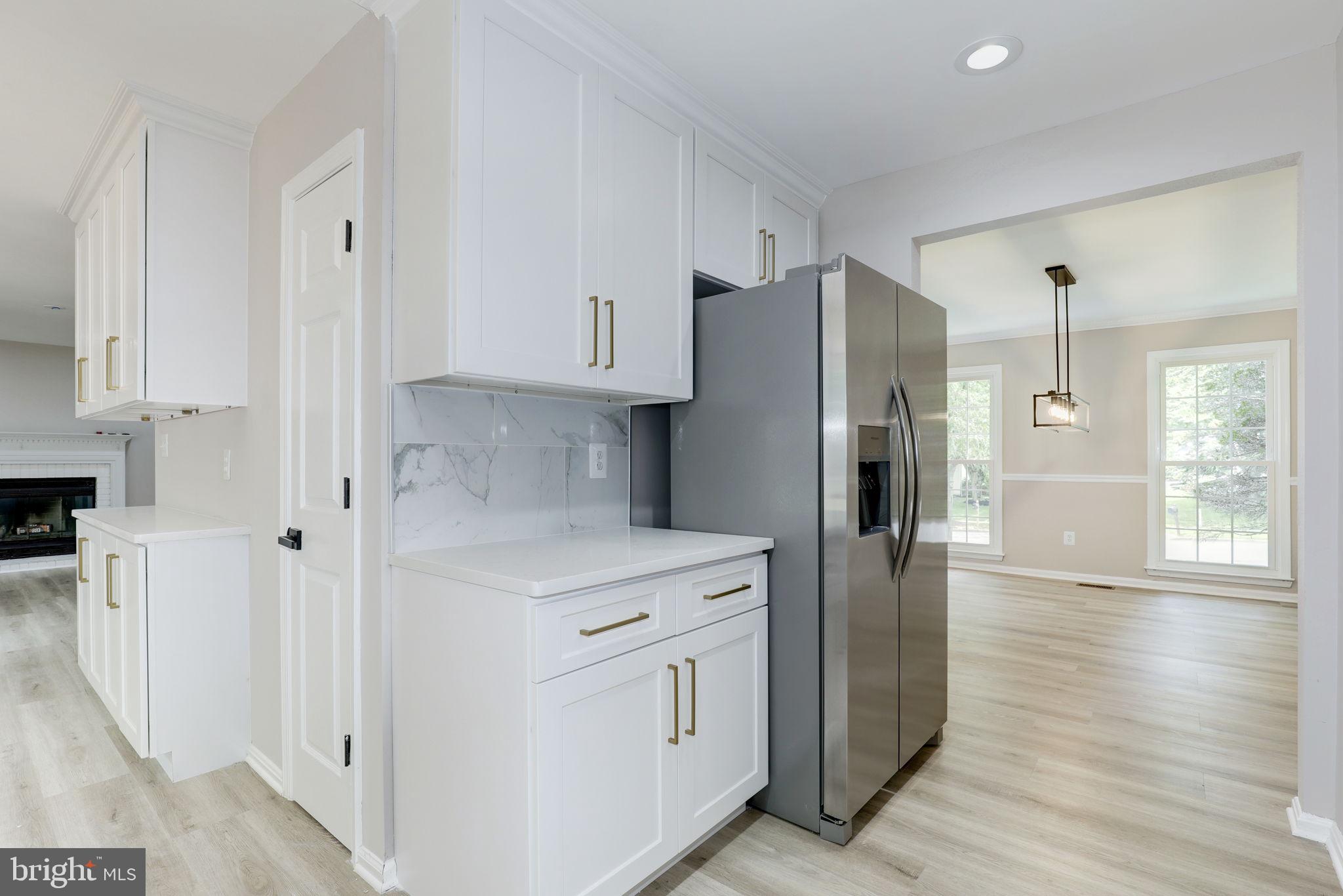 14422 Old Stage Road Bowie, MD 20720 - Photo 19 of 65 a kitchen with white cabinets and stainless steel appliances