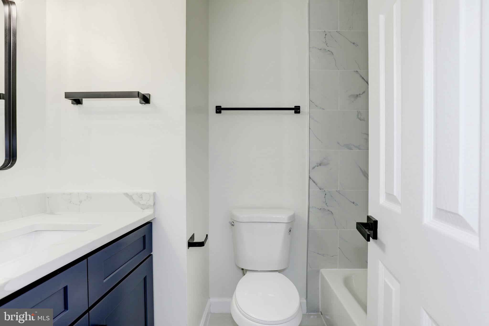 14422 Old Stage Road Bowie, MD 20720 - Photo 43 of 65 a bathroom with a granite countertop sink toilet and shower