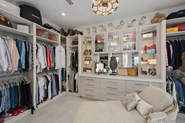a view of walk in closet with clothes and shoes