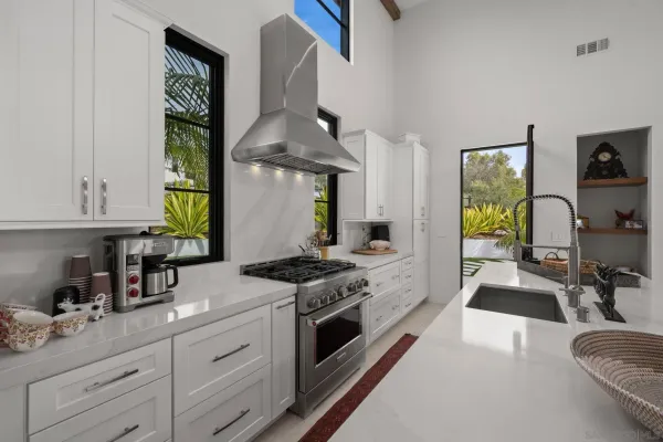 a kitchen with stainless steel appliances granite countertop a sink stove and cabinets