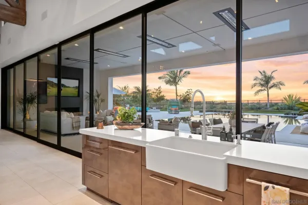 a room with sink and view of living room with a large window