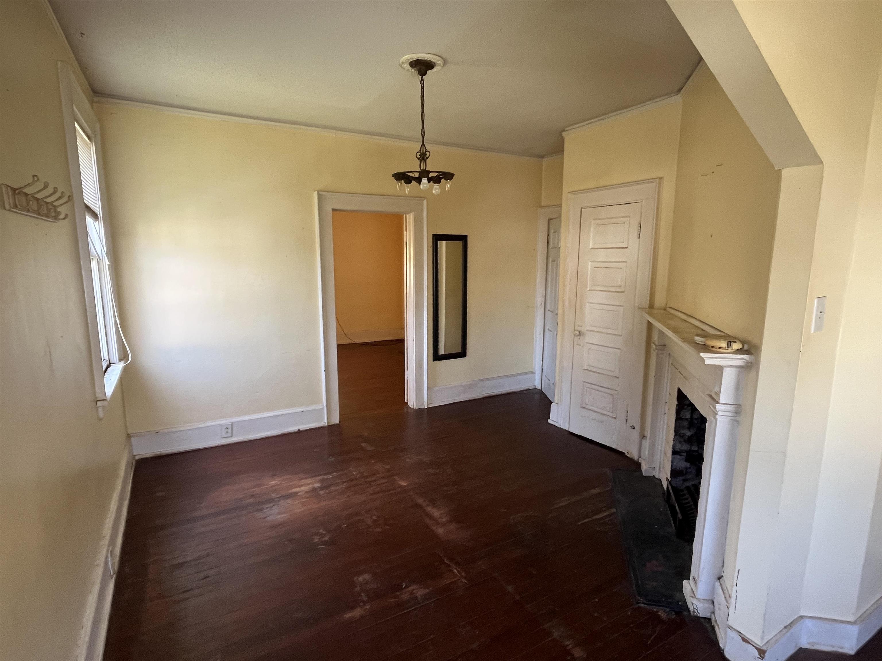 211 4th Street Mobile, AL 36611 - Photo 25 of 34 Unfurnished living room with dark wood-style floors, a fireplace, and suspended lighting
