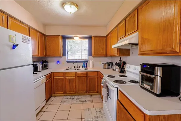 a kitchen with stainless steel appliances granite countertop a stove a sink dishwasher and a refrigerator