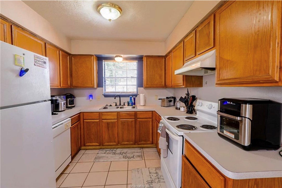 1802 Treehouse Trail, Unit A College Station, TX 77845 - Photo 5 of 13 a kitchen with stainless steel appliances granite countertop a stove a sink dishwasher and a refrigerator
