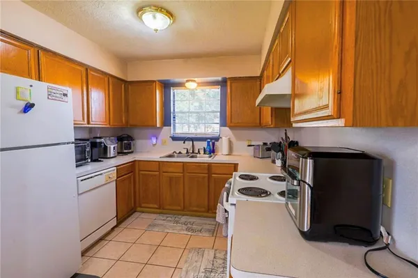 a kitchen with a sink a stove and a refrigerator