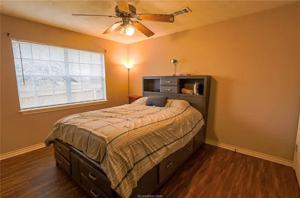 a bedroom with a bed and wooden floor
