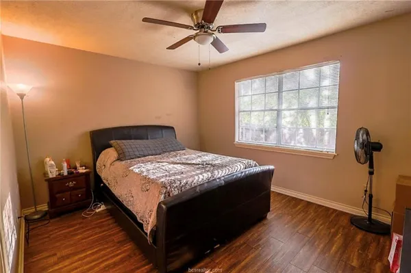 a bedroom with a bed and wooden floor