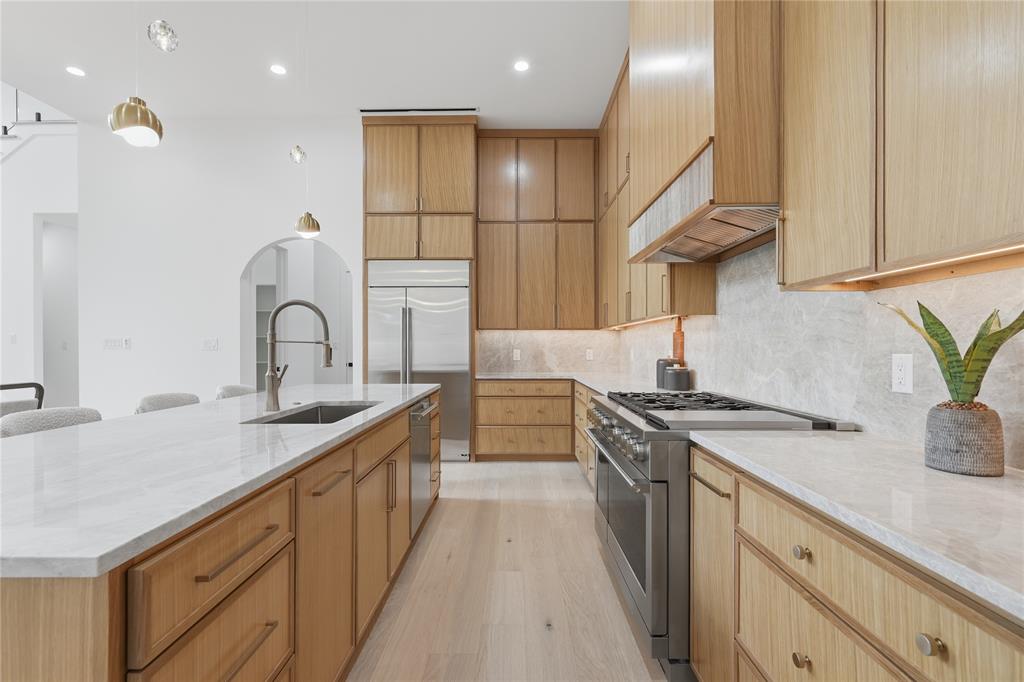 6038 Prospect Avenue Dallas, TX 75206 - Photo 11 of 40 Kitchen featuring an expansive island with a stainless steel sink and gooseneck faucet