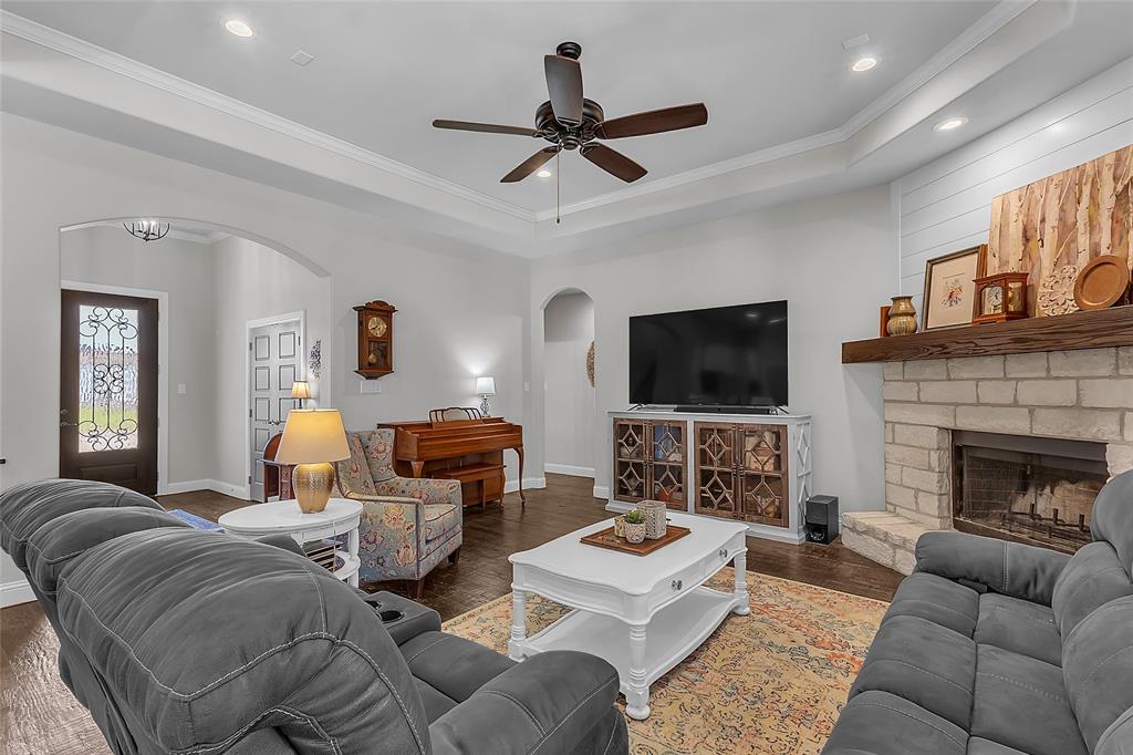 1014 Rennard Street Caddo Mills, TX 75135 - Photo 9 of 39 Spacious open-concept living area featuring, crown molding, hand-scraped wood flooring, a tray ceiling with recessed lighting, ceiling fan and fireplace