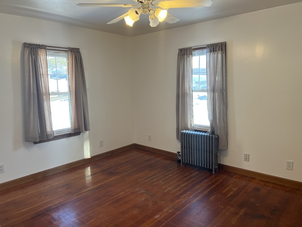 133 Douglas Road Gardner, MA 01440 - Photo 12 of 22 an empty room with wooden floor and windows