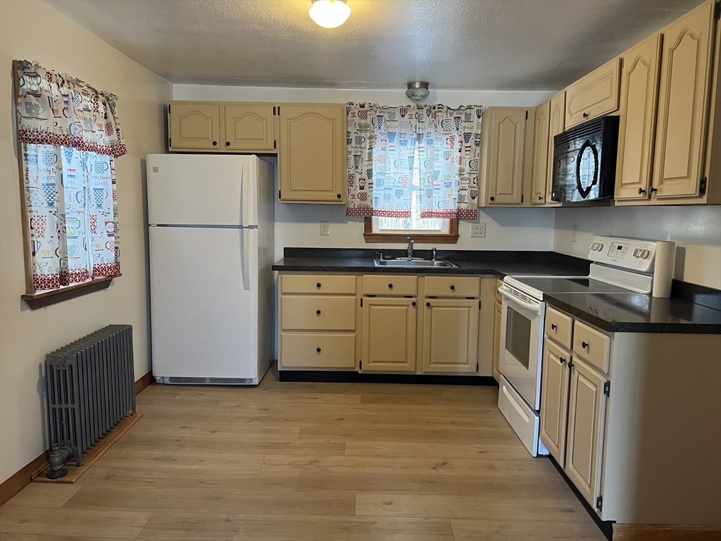 133 Douglas Road Gardner, MA 01440 - Photo 5 of 22 a kitchen with stainless steel appliances granite countertop a refrigerator a stove a sink and a microwave
