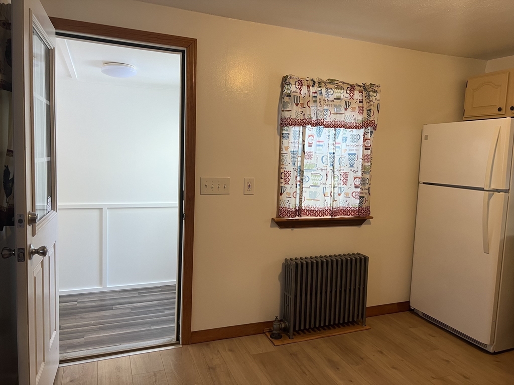 133 Douglas Road Gardner, MA 01440 - Photo 6 of 22 a view of a hallway with wooden floor and a cabinet
