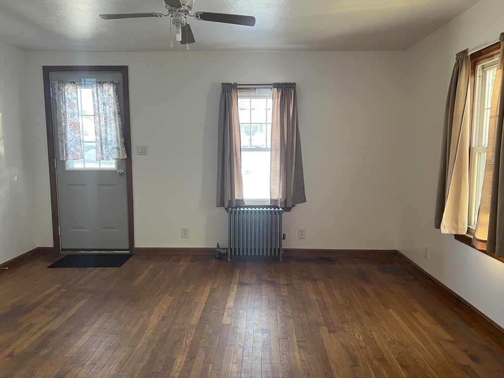 133 Douglas Road Gardner, MA 01440 - Photo 8 of 22 an empty room with wooden floor and windows
