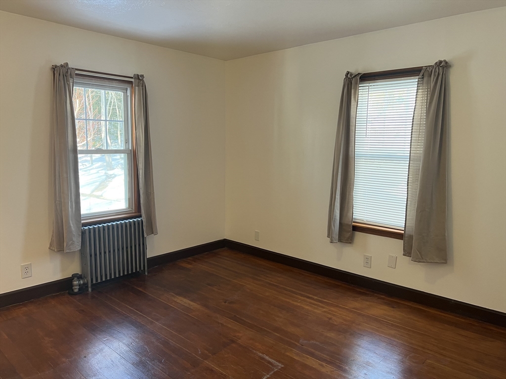 133 Douglas Road Gardner, MA 01440 - Photo 10 of 22 an empty room with wooden floor and windows