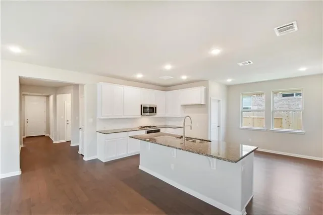 a kitchen with white cabinets and stainless steel appliances