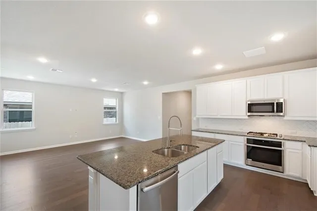 a kitchen with white cabinets and black appliances