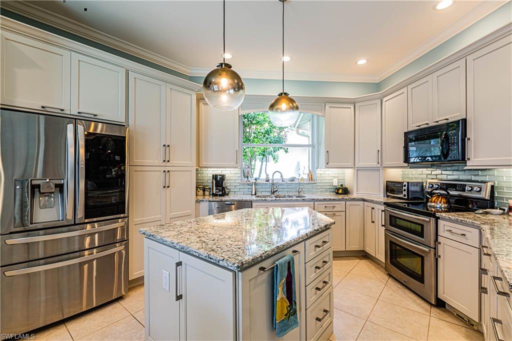 20196 Markward Crossing Estero, FL 33928 - Photo 2 of 28 a kitchen with granite countertop stainless steel appliances a sink and a refrigerator