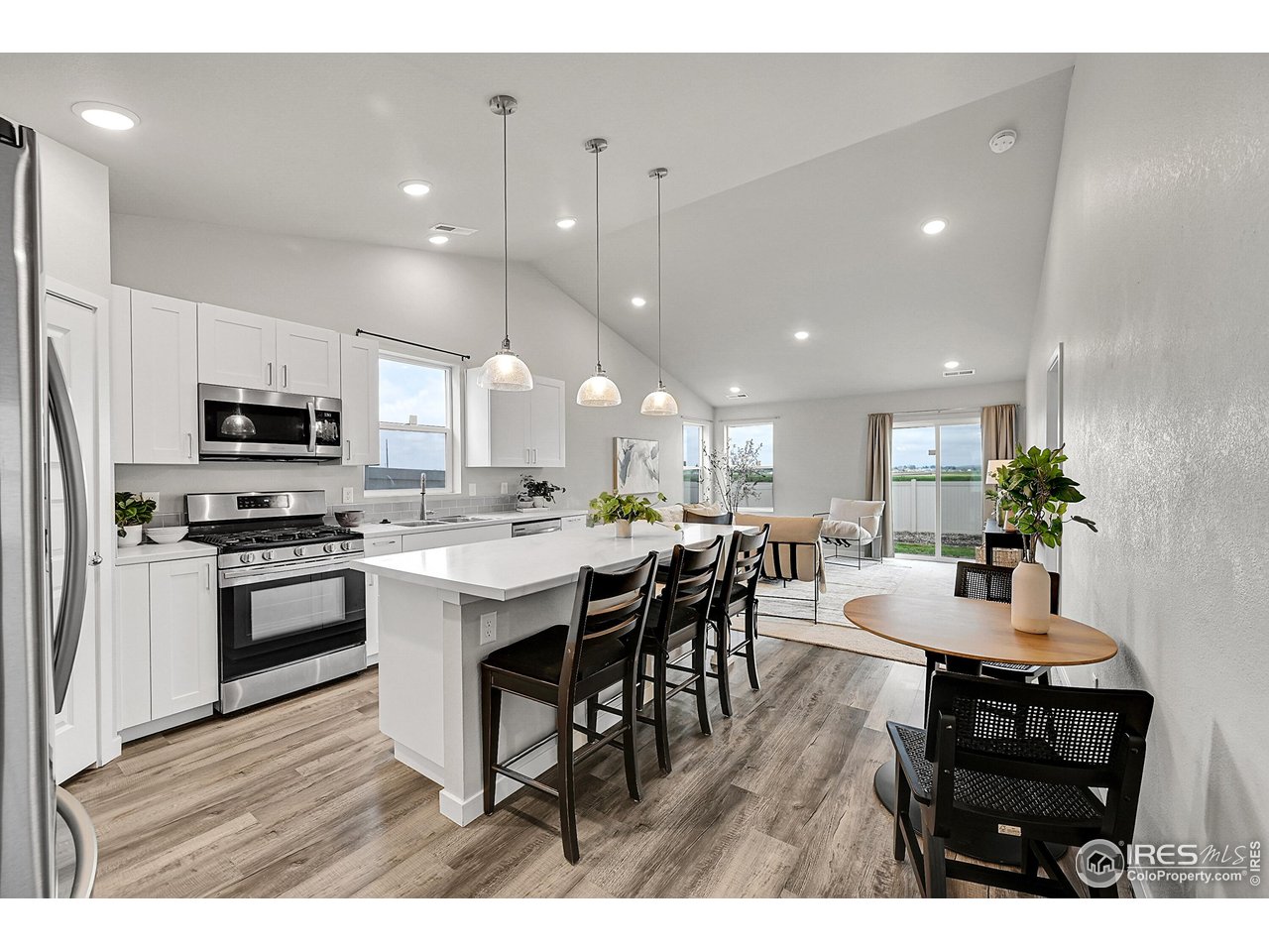 403 Pony Express Trail Ault, CO 80610 - Photo 6 of 31 a kitchen with stainless steel appliances kitchen island granite countertop a stove a sink a dining table and chairs