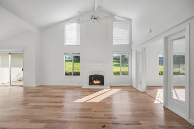 a view of a livingroom with a fireplace and windows