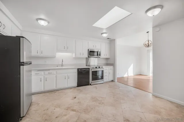 a large kitchen with cabinets and stainless steel appliances