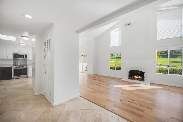 an empty room with windows and fireplace
