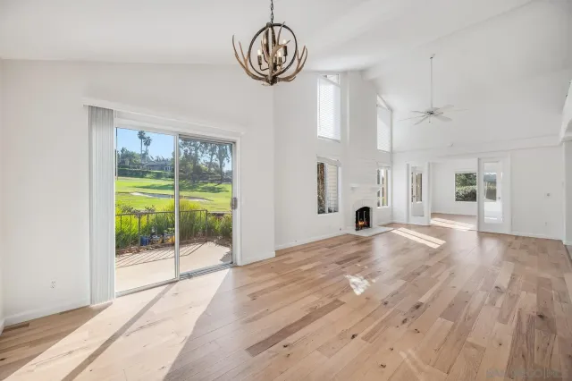 a view of an empty room with glass door and windows