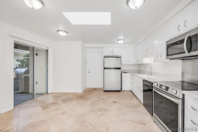 a kitchen with stainless steel appliances granite countertop a refrigerator sink and stove