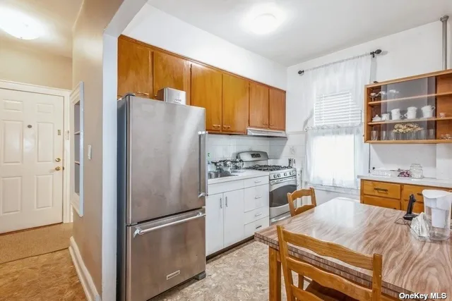 a kitchen with stainless steel appliances granite countertop a refrigerator and a stove top oven