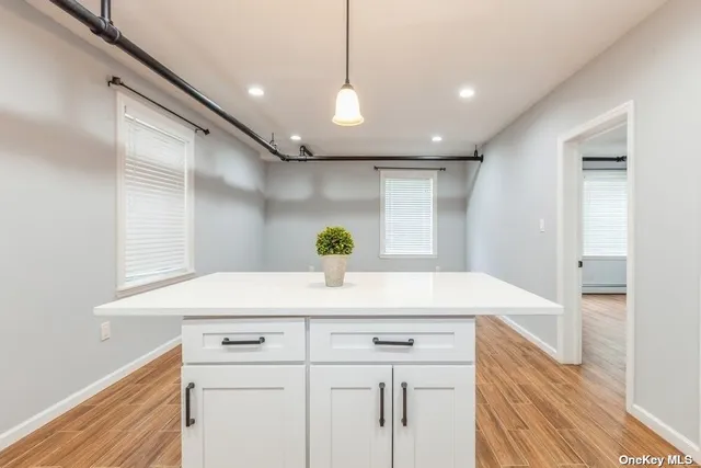 a kitchen with kitchen island white cabinets and wooden floor