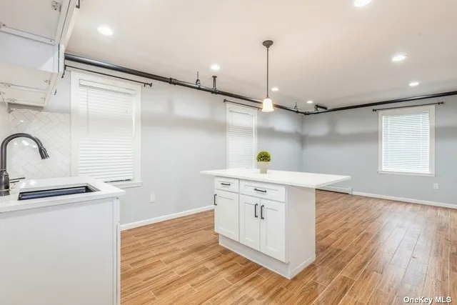 a kitchen with stainless steel appliances granite countertop a sink a stove and wooden floor