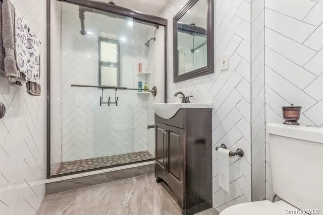 a bathroom with a granite countertop shower mirror and toilet