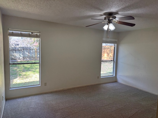 331 Fantail Loop, Unit B Austin, TX 78734 - Photo 12 of 16 Spare room with a textured ceiling, a ceiling fan, and dark carpet